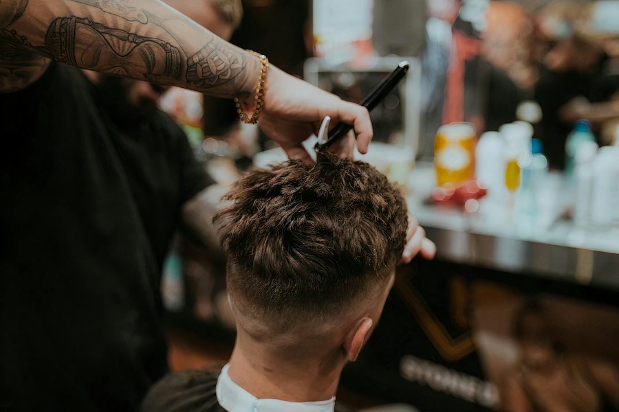 Barber finishing a fade with clippers