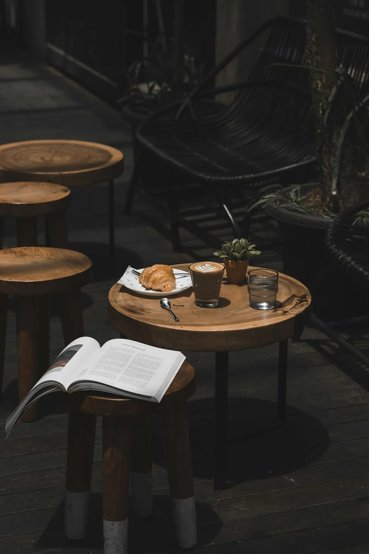 Round café table with a coffee and an open book