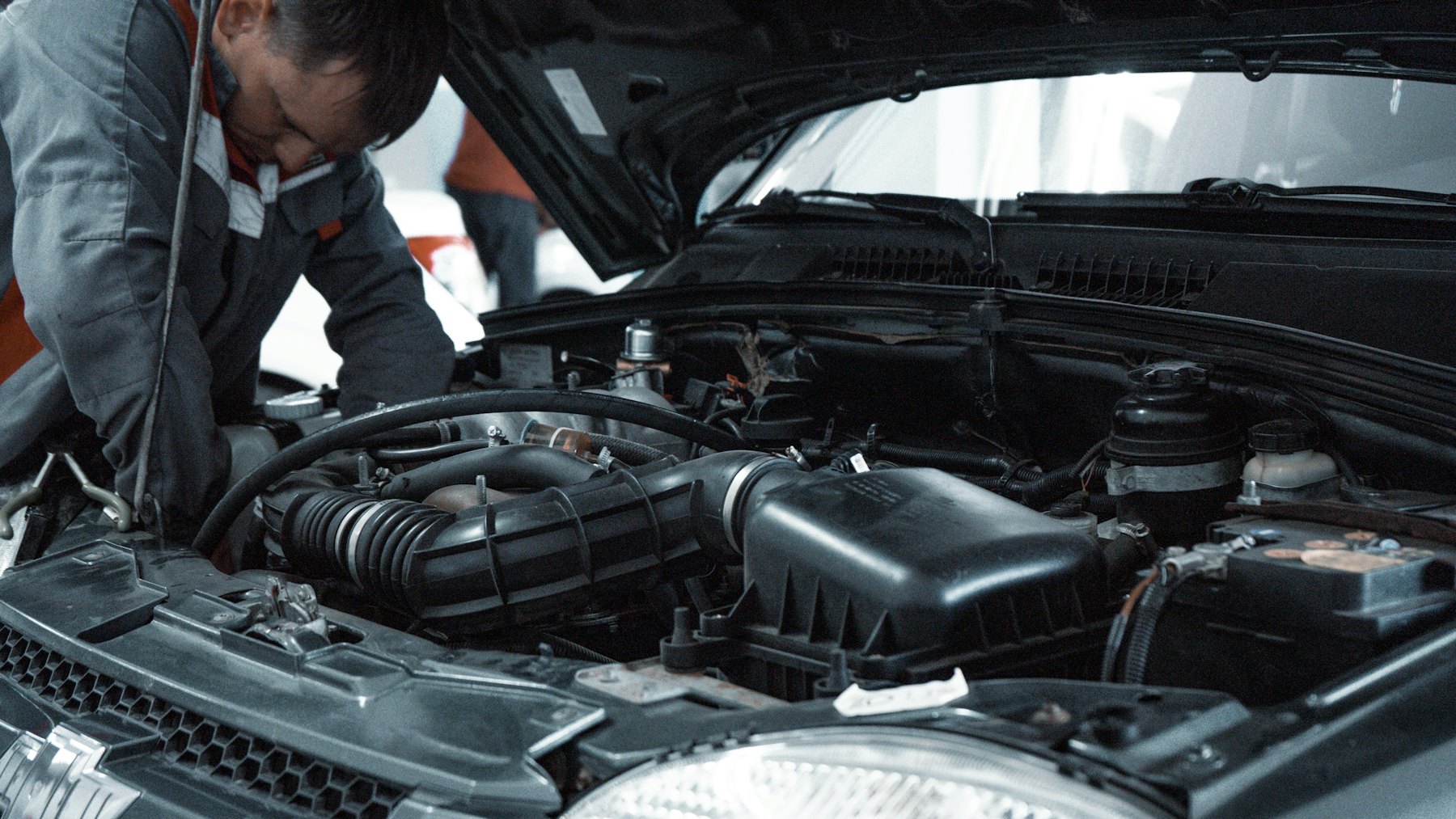 Mechanic inspecting the engine of a car with the bonnet open