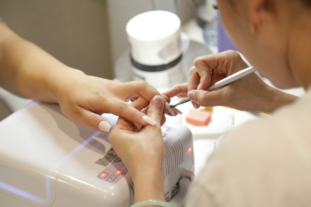 Nail technician doing a manicure at the desk
