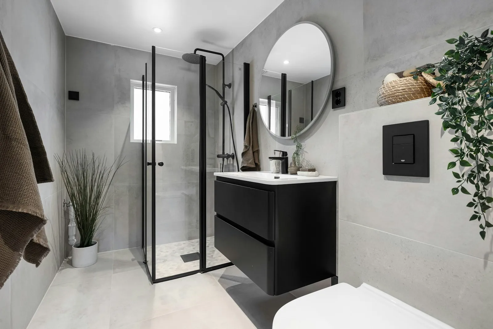 Grey tiled shower room with black fittings