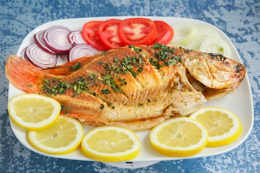 Grilled whole fish with lemon slices