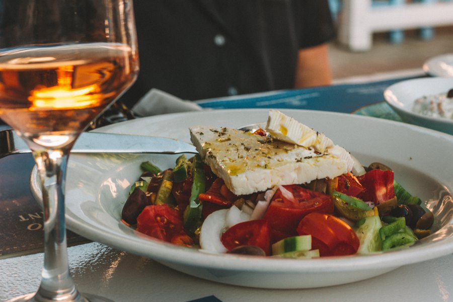 Greek village salad with feta and a glass of rosé